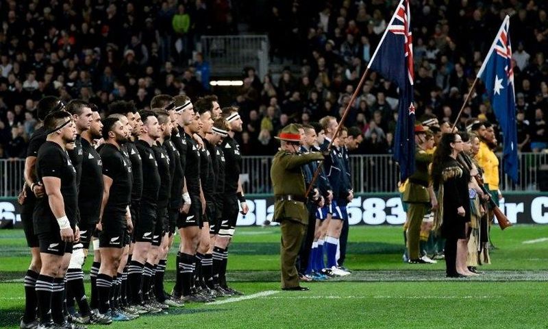 New Zealand (L) and Australia rugby players observe a moment of silence due to the passing of All Blacks legend Colin Meads, in Dunedin, on August 26, 2017