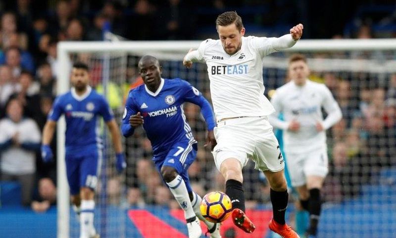 Swansea City's midfielder Gylfi Sigurdsson (C) runs forward with the ball during the English Premier League football match against Chelsea February 25, 2017