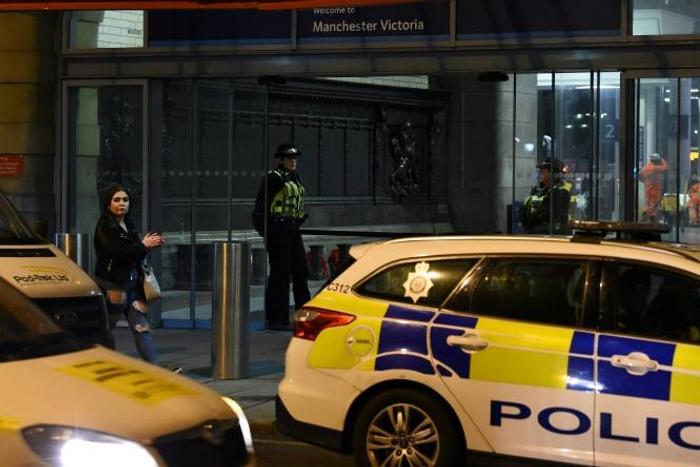 Police officers stand near a cordon at Manchester Victoria Station following a stabbing