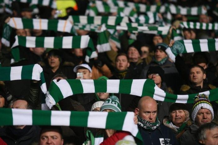 Celtic fans hold up team scarves in Glasgow