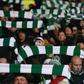 Celtic fans hold up team scarves in Glasgow
