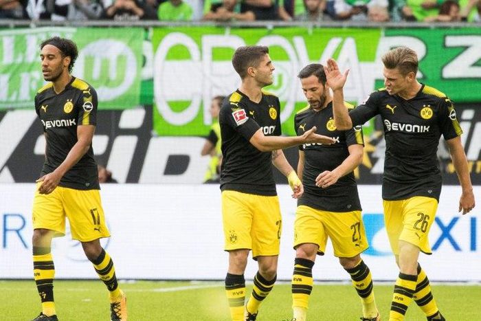 Dortmund players celebrate scoring the opening goal during the Bundesliga match against Wolfsburg