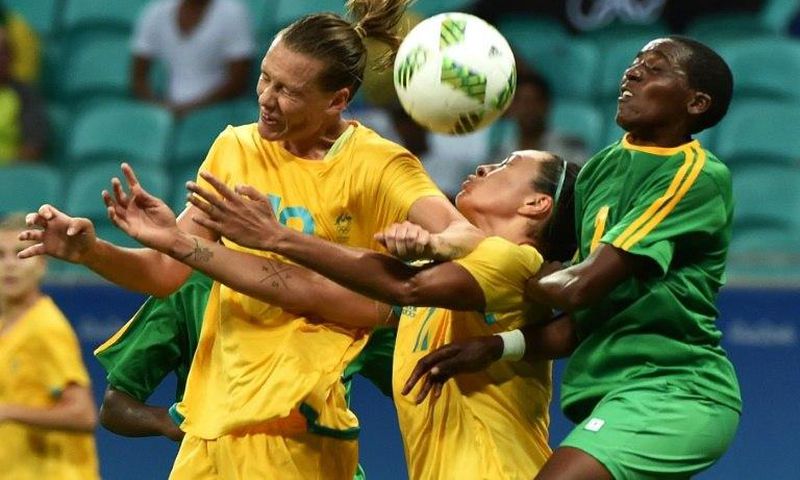 Emily Van Egmond (L) and Kyah Simon of Australia fight for the ball with Zimbabwe's Lynett Mutokuto during their Rio 2016 Olympic Games women's football match, in Salvador