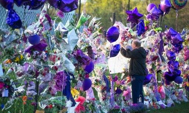 A fan visits a memorial outside Paisley Park, the home and studio of Prince, in April, 2016 in Chanhassen, Minnesota