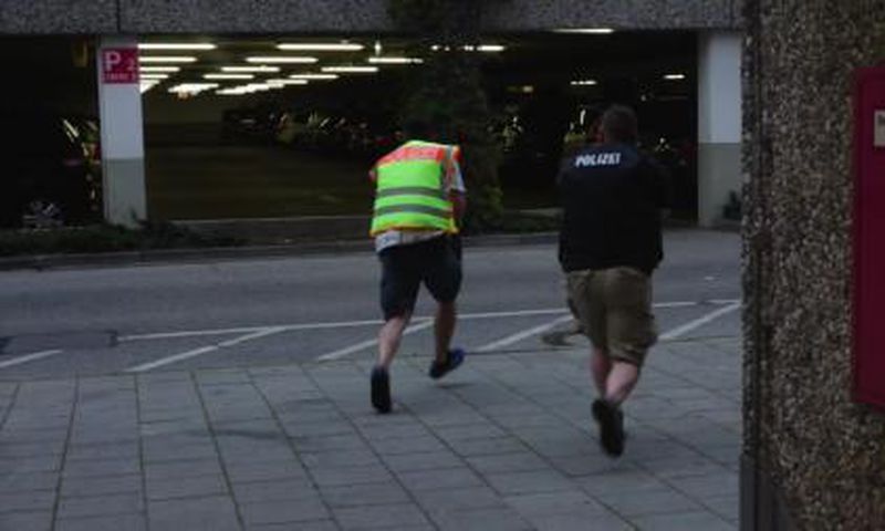 A screen grab taken from video footage shows plain clothes police officers running towards car park of the Olympia shopping mall during shooting rampage in Munich, Germany July 22, 2016.