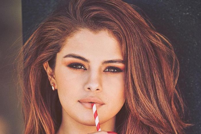 Selena Gomez sipping from a bottle of Coca-Cola.