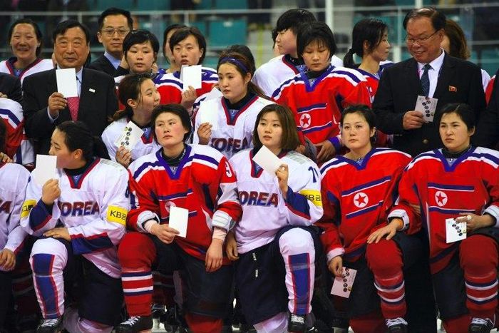 PyeongChang 2018 Organising Committee President Lee Hee-Beom (L top) poses with players from South Korea (white) and North Korea (red) after the IIHF women's world ice hockey championship match in Gangneung on April 6, 2017