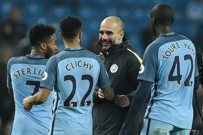 Manchester City's manager Pep Guardiola (C) congratulates Raheem Sterling, Gael Clichy and Yaya Toure after winning an English Premier League match, at the Etihad Stadium in Manchester, on December 18, 2016