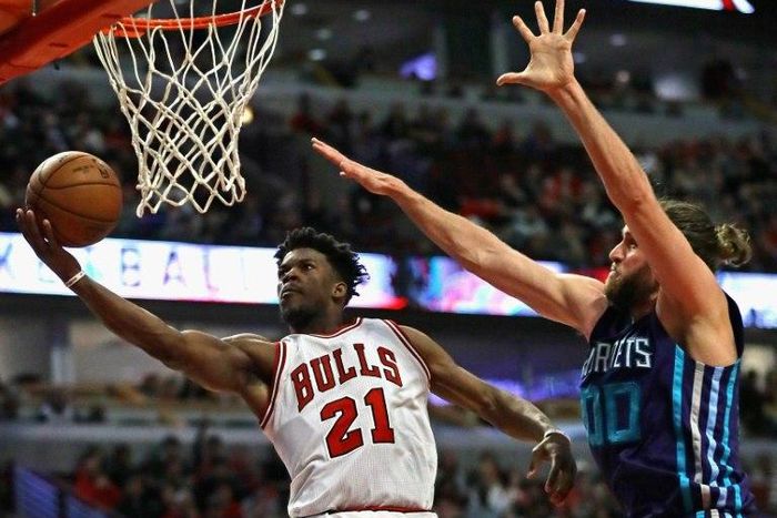 Jimmy Butler of the Chicago Bulls puts up a shot past Spencer Hawes of the Charlotte Hornets on his way to a game-high 52 points as the Bulls win 118-111