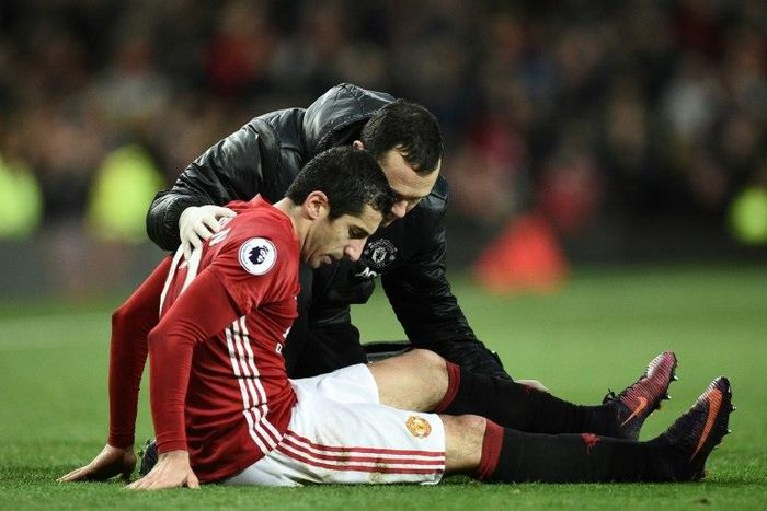 Manchester United midfielder Henrikh Mkhitaryan receives attention after picking up an injury during the English Premier League match against Tottenham Hotspur at Old Trafford on December 11, 2016