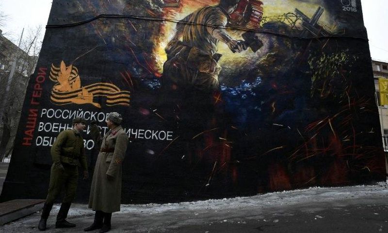 Men dressed in Red Army World War II uniforms take part in the opening of a street art-style painting promoting the new Russian film "The Panfilov 28" in Moscow