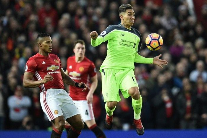 Manchester United's midfielder Antonio Valencia (L) vies with Liverpool's midfielder Roberto Firmino during the English Premier League football match between Manchester United and Liverpool on January 15, 2017
