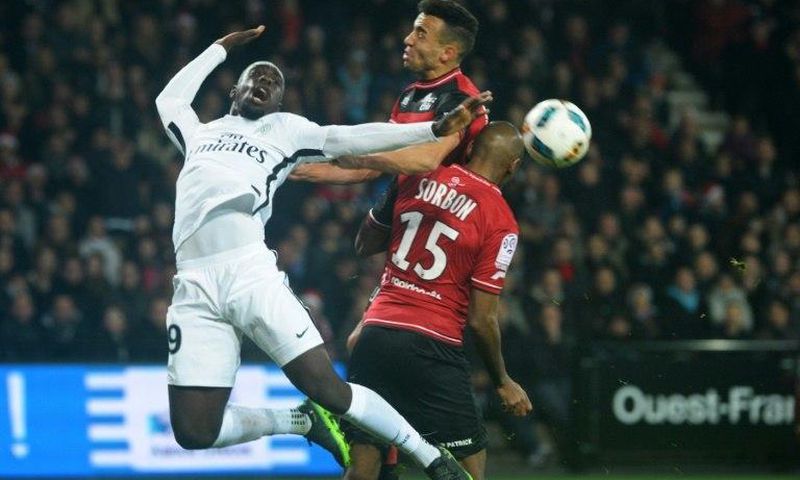 Paris Saint-Germain's Jean-Kevin Augustin (L) vies with Guingamp's Jeremy Sorbon (R) on December 17, 2016 at the Roudourou stadium in Guingamp, western of France