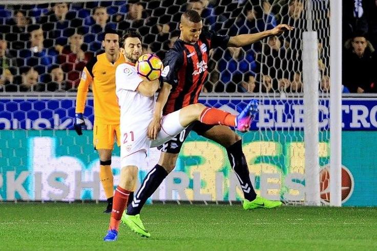 Sevilla's defender Nicolas Pareja (C) fights for the ball with Alaves' forward Deyverson Silva during a Spanish league football match on March 6, 2017