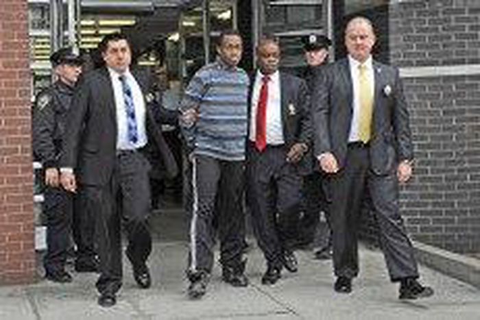 Chanel Lewis being held in handcuffs.