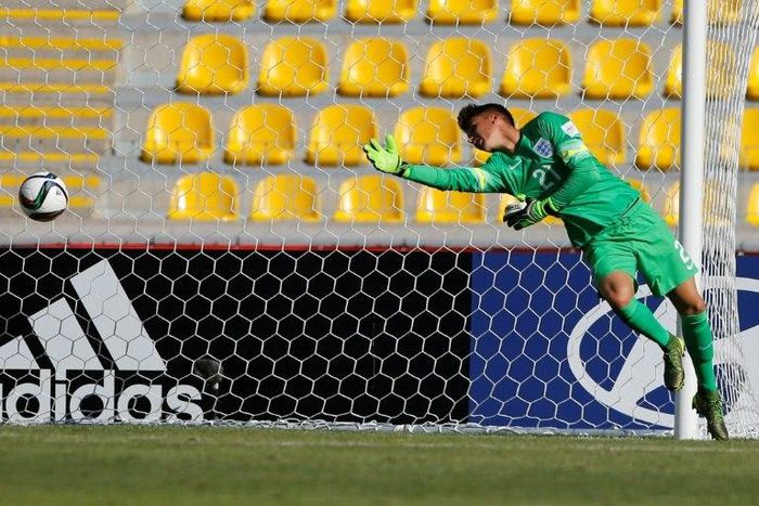 England's goalkeeper Alfie Whiteman jumps for the ball after the shot of Guinea's Naby Bangoura (not in picture) during an Under 17 World Cup match at La Portada stadium in La Serena on October 17, 2015