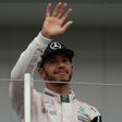 Third-placed Mercedes AMG Petronas F1 Team's British driver Lewis Hamilton waves from the podium after the Formula One Japanese Grand Prix, at the Suzuka Circuit, on October 9, 2016
