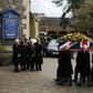 Rita Taylor (L), the wife of former England manager and manager of Watford football club Graham Taylor watches as his coffin is brought into church during his funeral service in Watford on February 1, 2017