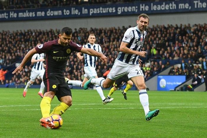 Manchester City's striker Sergio Aguero (L) shoots to score the opening goal of the English Premier League football match between West Bromwich Albion and Manchester City at The Hawthorns stadium in West Bromwich, central England, on October 29, 2016