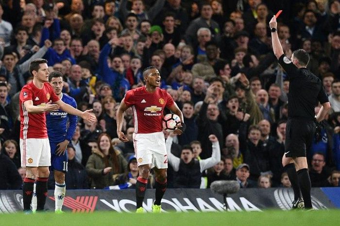 English referee Michael Oliver (R) shows a red card to Manchester United's Spanish midfielder Ander Herrera (L) during their match against Chelsea in London on March 13, 2017