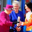 Retired cyclist Anna Meares (R) from Australia receives the baton from Britain's Queen Elizabeth II during the launch of the Queen's baton relay for the 2018 Commonwealth Games at Buckingham Palace in London, March 13, 2017