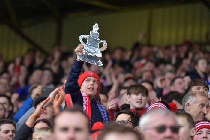 Lincoln fans celebrate after winning the English FA Cup fifth round football match between Lincoln City and Burnley February 18, 2017
