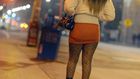 A sex worker walks down a lonely street at night.