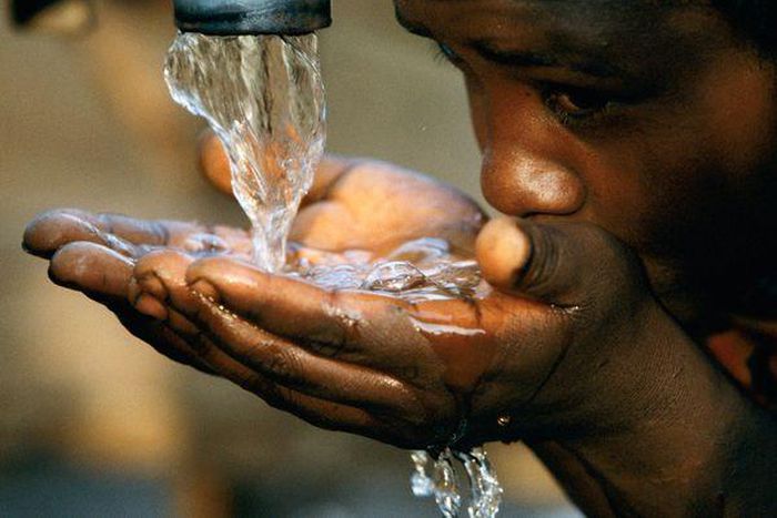  A girl drinking water from a faucet