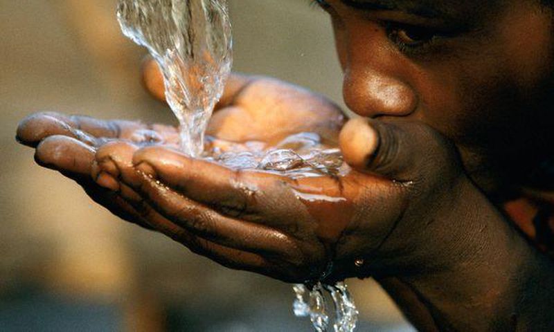  A girl drinking water from a faucet