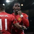 Manchester United's Anthony Martial (L) embraces Paul Pogba as he celebrates scoring their second goal from the penalty spot against Fenerbahce on October 20, 2016