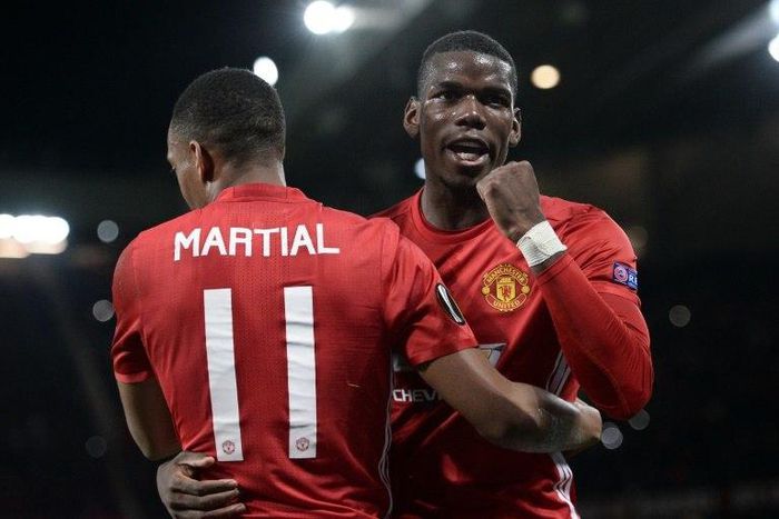 Manchester United's Anthony Martial (L) embraces Paul Pogba as he celebrates scoring their second goal from the penalty spot against Fenerbahce on October 20, 2016