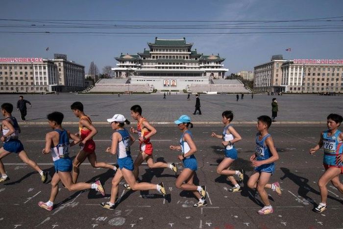 Competitors run through Kim Il-Sung square during the Pyongyang Marathon in the North Korean capital