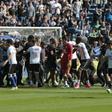 Stewards and Lyon staff members try to stop Bastia's supporters who invade the pitch to fight with Lyon players during warm up prior to the French L1 Football match between Bastia and Lyon on April 16, 2017, at the Armand Cesari stadium