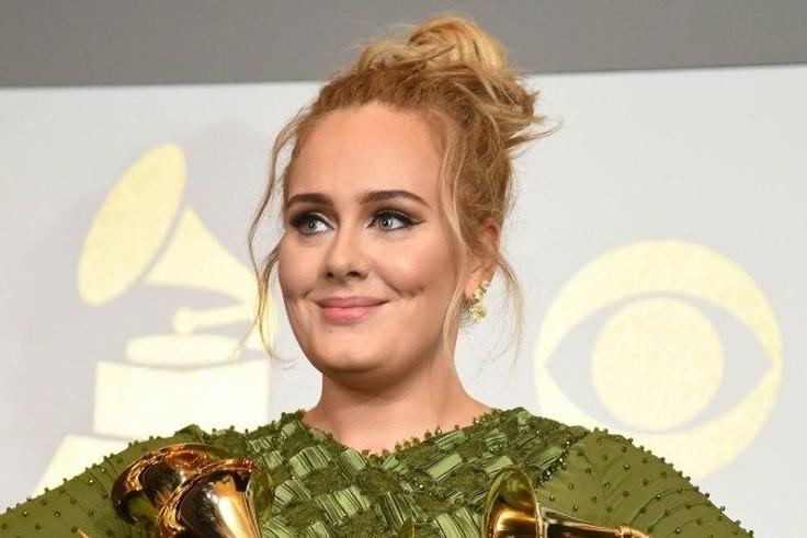 Adele poses in the press room with her five trophies, including the top two Grammys of Album and Record of the Year for her blockbuster hit "Hello" and the album "25"