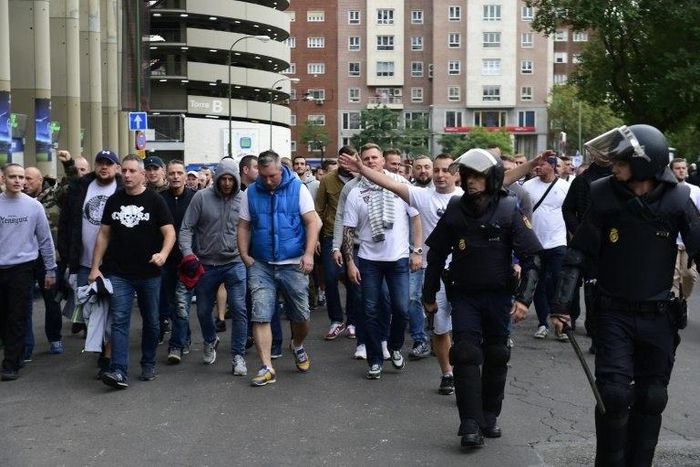 Legia Warsaw football fans are escorted by Spanish police into stadium ahead of the match between Real Madrid and Legia Warszawa at the Santiago Bernabeu stadium in Madrid on October 18, 2016