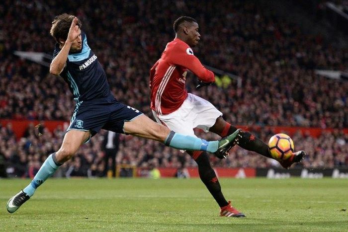 Manchester United's midfielder Paul Pogba (R) attemps to shoot past Middlesbrough's defender George Friend during the English Premier League football match at Old Trafford in Manchester, north west England, on December 31, 2016