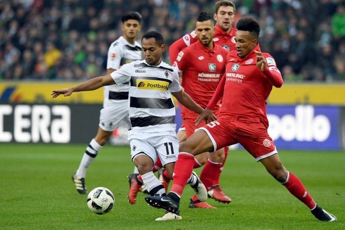 Moenchengladbach's forward Raffael (L) and Mainz' midfielder Jean Philippe Gbamin fight for the ball during their Bundesliga match in Moenchengladbach, on December 11, 2016