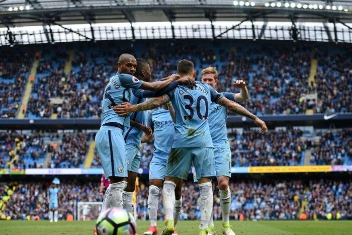 Manchester City's Nicolas Otamendi (2R) is mobbed by teammates as they celebrate scoring his team's fifth goal during their Premier League match against Crystal Palace at the Etihad Stadium in Manchester on May 6, 2017