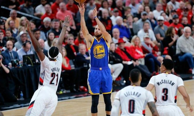Stephen Curry of the Golden State Warriors shoots the ball over Noah Vonleh of the Portland Trail Blazers in Game Three of the Western Conference quarter-finals of the 2017 NBA Playoffs, in Portland, Oregon, on April 22