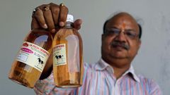 An Indian holding bottled Cow Urine