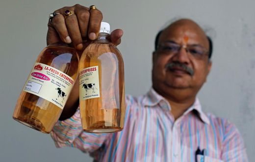 An Indian holding bottled Cow Urine