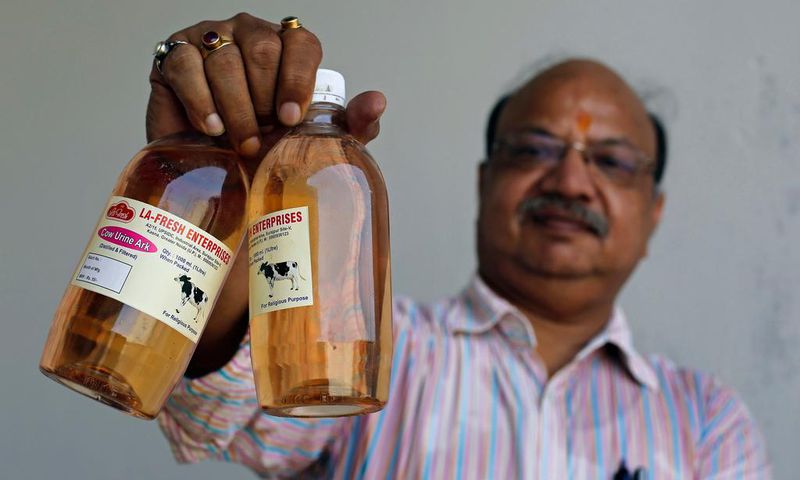 An Indian holding bottled Cow Urine
