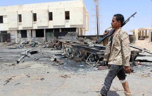 A member of the security team walks past the remains of a burnt car after a suicide car bomber hit a Libyan police station west of the besieged Islamic State stronghold of Sirte June 16, 2016. REUTERS/Stringer