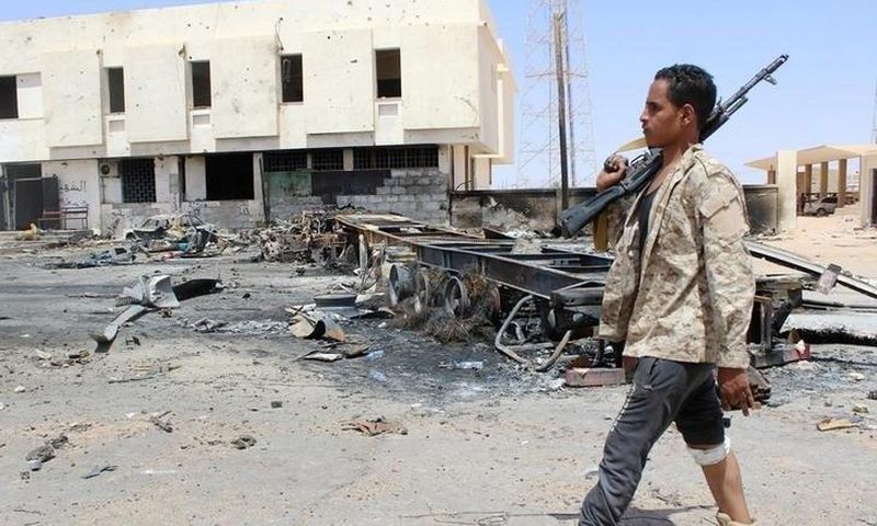 A member of the security team walks past the remains of a burnt car after a suicide car bomber hit a Libyan police station west of the besieged Islamic State stronghold of Sirte June 16, 2016. REUTERS/Stringer