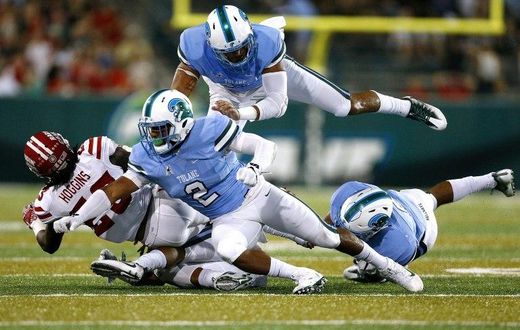 Darius Hoggins of the Louisiana-Lafayette Ragin Cajuns is tackled by Nico Marley (#2) of the Tulane Green Wave and Peter Woullard, top, during the first half of a game at Yulman Stadium on September 24, 2016 in New Orleans, Louisiana