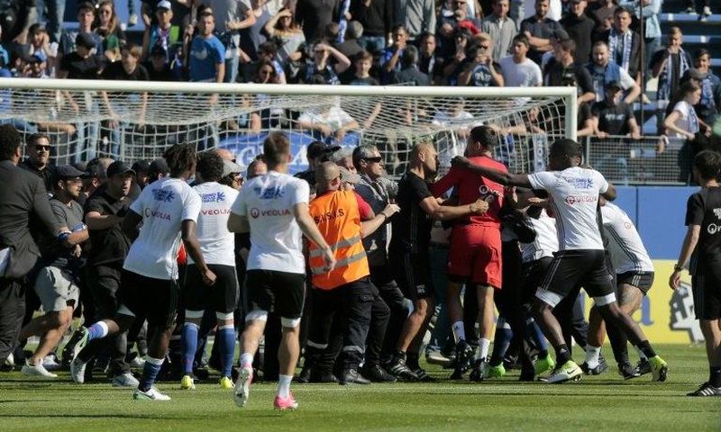 Bastia supporters invade the pitch to try to attack Lyon's Portuguese goalkeeper Anthony Lopes (in red) and others players during their warm-up prior to the French Ligue 1 match at the Armand Cesari stadium in Bastia, Corsica on April 16, 2017