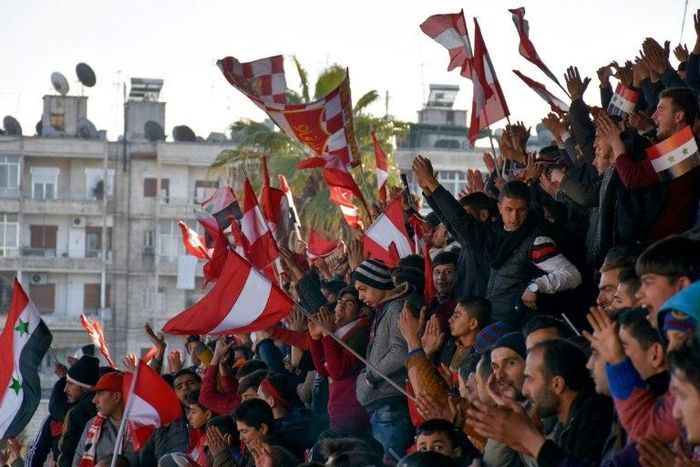 Al-Ittihad supporters wave flags bearing their team's colors for the first Syrian league football match in Aleppo since rebels took over the east part of the Syrian city on January 28, 2017