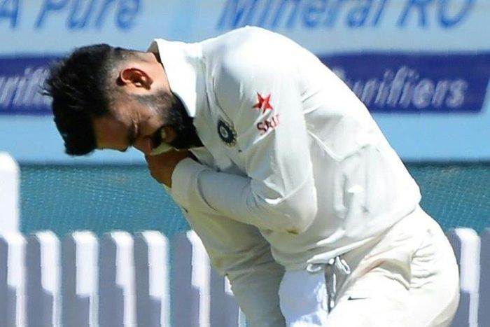India's captain Virat Kohli holds his shoulder after he was injured while fielding during the first day of the third Test against Australia in Ranchi, on March 16, 2017