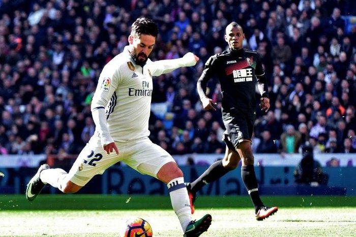 Real Madrid's midfielder Isco (L) kicks the ball to score against Granada on January 7, 2017
