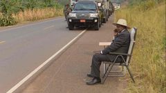 Ugandan president, Yoweri Museveni, making a phone call on the road side